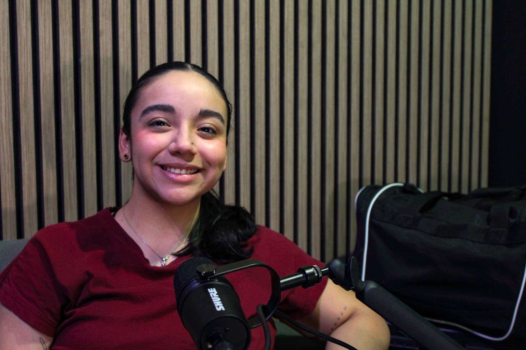 Invitada sonriendo en cabina de podcast